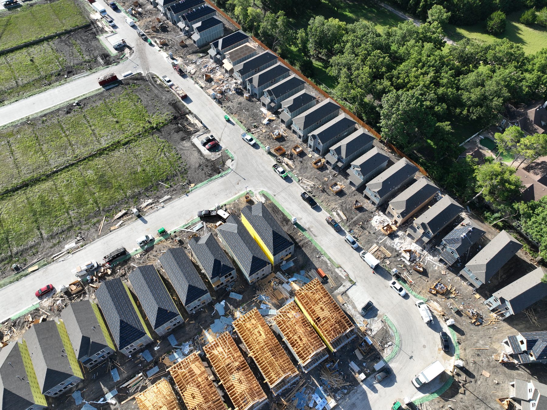 Aerial view of completed and framing homes lining a finished street at Arbor South Phase 1 in Princeton, Texas