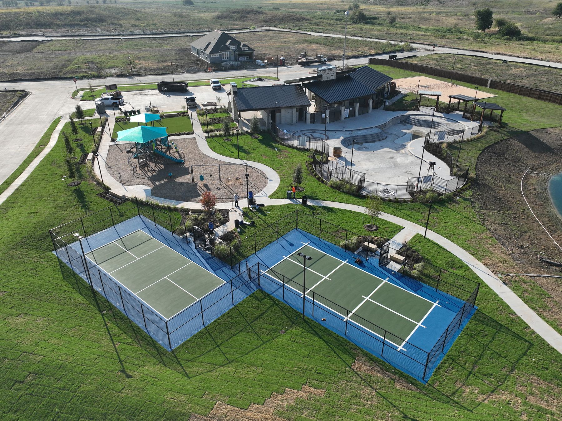 Aerial view of the Clearview Ranch amenity center in Royse City, Texas — two pickleball courts, a shaded playground, and the clubhouse and pool beyond