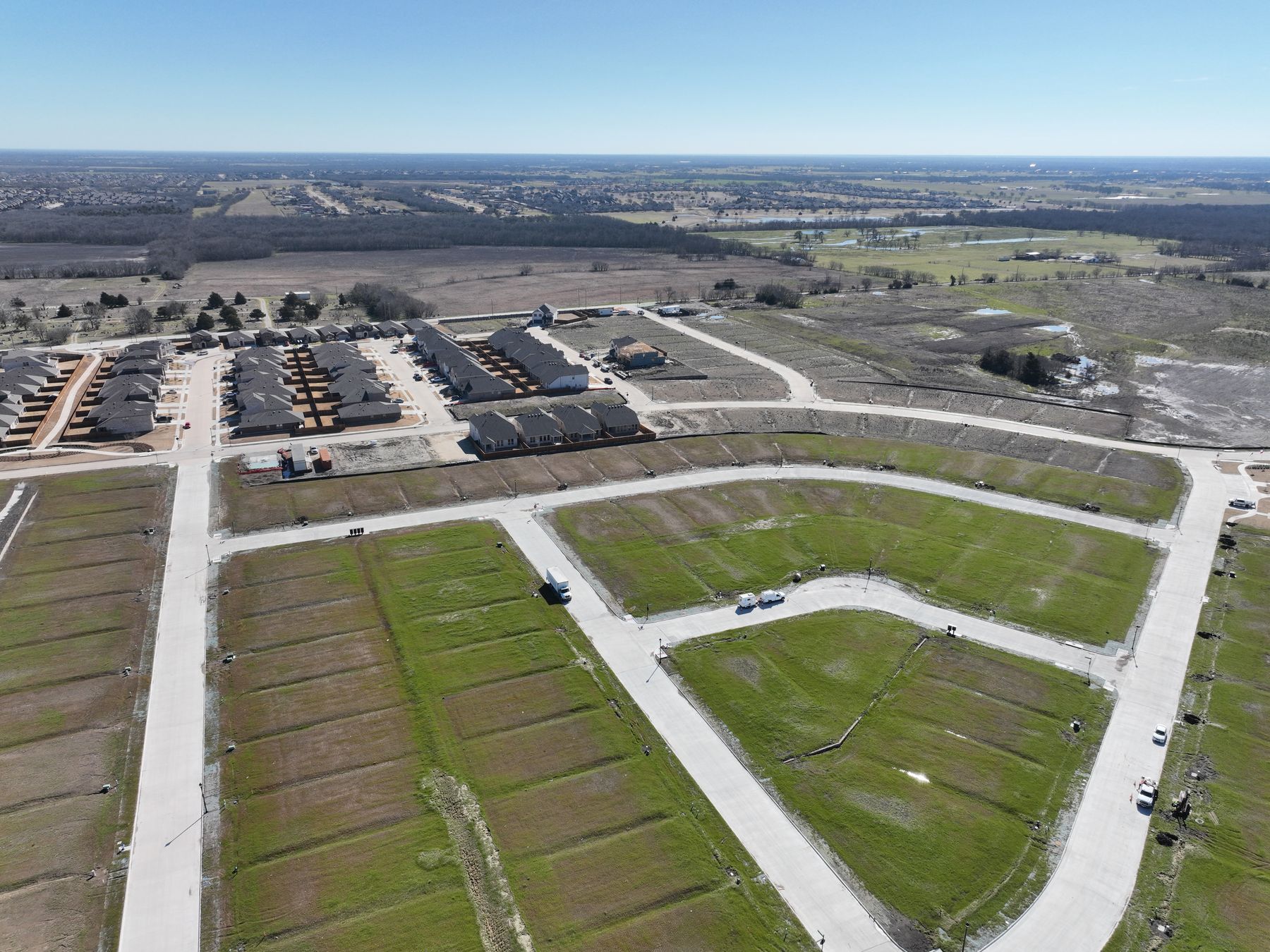 Aerial view of finished, paved homesites at Liberty Crossing Phase 2 in Royse City, Texas, with the completed homes of Phase 1 beyond